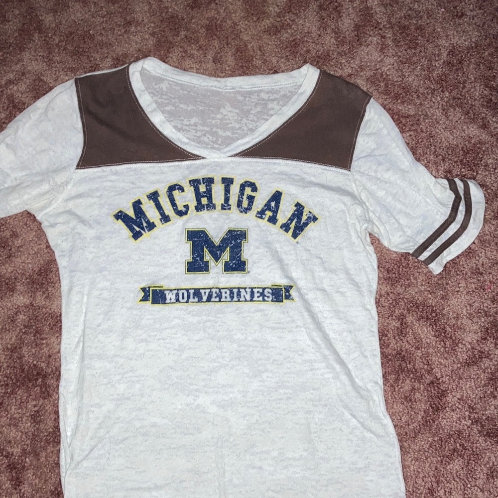 Two set of Michigan and Michigan state shirts.
